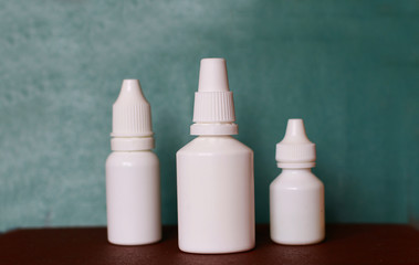 nasal spray nose drops white vials on a green background
