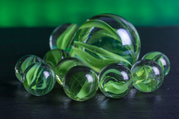 group of green glass marbles with green light background