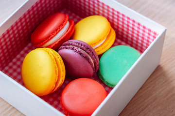 Fototapeta na wymiar French traditional delicious dessert. Sweet macaroons in a gift box on wooden table