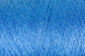 background of shiny blue viscose yarn on a cone