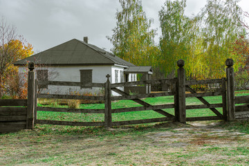 Rural house behind a wooden fence