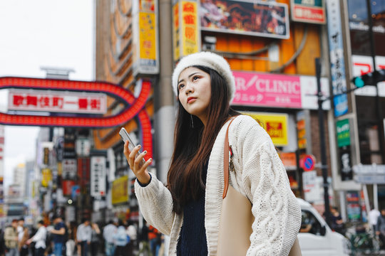 スマートフォンを持ちながら東京観光する女性
