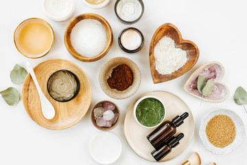 Beauty treatment ingredients for making homemade skin care cosmetic mask. Various bowl with clay, cream, essential oil and natural ingredients  on white table background. Organic spa cosmetic products