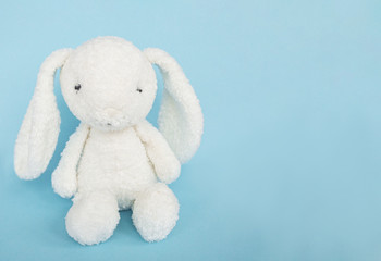 Easter bunny white rabbit with on blue background. Copy space.