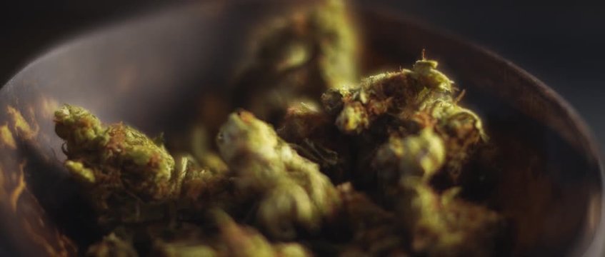 Close up of cannabis buds in a bowl, shallow depth of field, slow motion, BMPCC 4K. Marijuana, weed, smoking drugs concept. CBD, THC footage