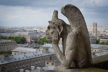 Fototapeta na wymiar Gargoyle thinking on top of Notre Dame