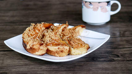 Banana crispy on white plate and a cup of drink with wood background. 