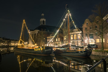 Scenic night view of ships with christmas decoration in the old harbor of Schiedam, Netherlands