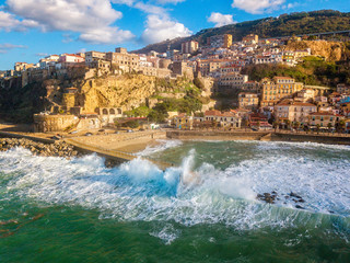 Obraz premium Aerial view of Pizzo Calabro, broken pier, castle, Calabria, tourism Italy. Houses on the rock. On the cliff stands the Murat Aragonese castle. Seafront at sunset. Sea storm and waves with wind