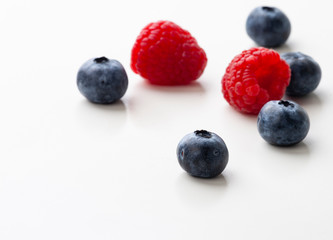 blueberries and raspberries isolated on white