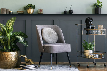 Stylish and modern composition of living room with design gray armchair, gold liquor cabinet,...