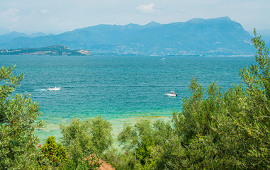 Fototapeta premium Jamaica Beach at Sirmione, on Lake Garda, renowed for its beautiful emerald water. Province of Brescia, Lombardy, Italy.