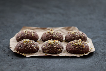 Dessert chocolate cookies with walnuts and coffee on a dark gray background