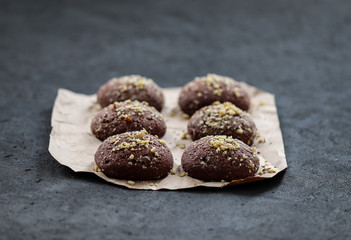 Dessert chocolate cookies with walnuts and coffee on a dark gray background