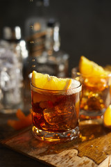 Tasty alcoholic old fashioned cocktail with orange slice.