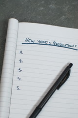 pen and notebook with a list of new years resolutions
