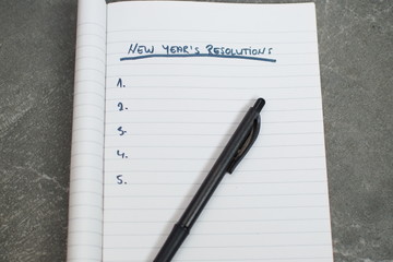 pen and notebook with a list of new years resolutions