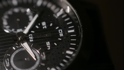 A beautiful black analog watch in black background - Close up