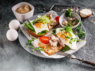 Delicious breakfast or lunch. Sandwiches with egg, pate, herbs and cheese on a gray background. Close-up