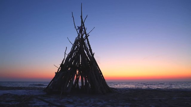 Driftwood teepee with Christmas Star on top, Crescent Beach, Algoma, Wisconsin, December, time lapse sunrise.