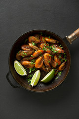 Fried shrimp with cilantro and lime in a frying pan. top view. Beer snack