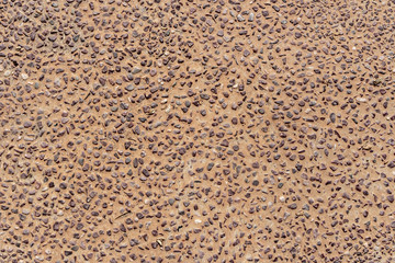 Beautiful texture of path of gray smooth stones on the orange background is in the park