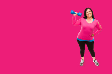 Middle Aged Hispanic Woman In Workout Clothes Holding Dumbbell Against A Bright Magenta Pink Background