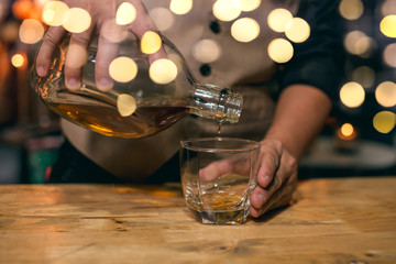 Barman pouring whiskey whiskey glass beautiful night