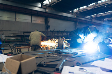 Naklejka premium factory workers cover the face with a mask. work, welding and metal cutting