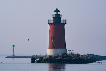 A red lighthouse on the bay in Delaware during twilight 