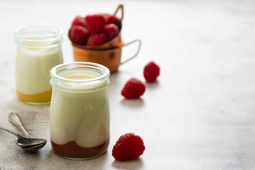 Fresh yogurt in glass jar with fruits. Healthy food, milk diary.