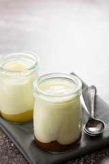 Fresh yogurt in glass jar with fruit jam. Healthy food, milk diary.