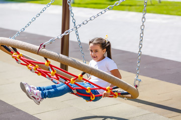 attractive little girl on outdoor playground equipment