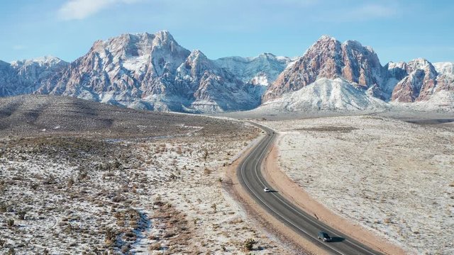 Aerial shot of cars driving in snow desert mountain landscape in Red Rock Canyon