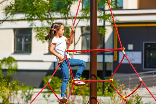attractive little girl on outdoor playground equipment