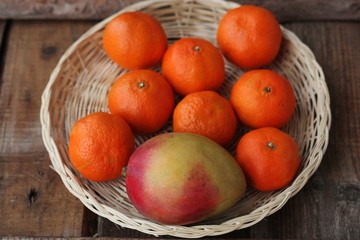 Fresh mango and tangerines on the table