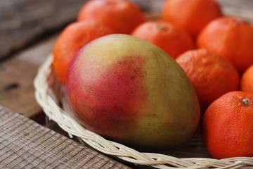 Fresh mango and tangerines on the table