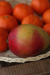 Fresh mango and tangerines on the table