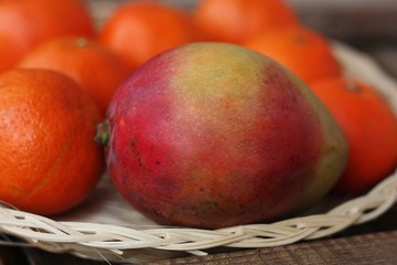 Fresh mango and tangerines on the table