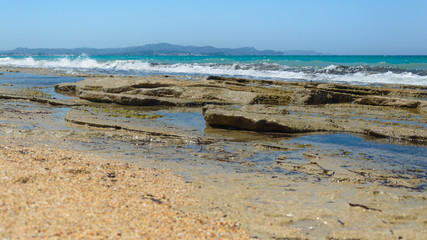 Pebble sandstone beach, waves breaking in from the sea.