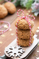 Stack of homemade oatmeal cookies on sleigh. Christmas healthy cookies, biscuits. Rustic wooden table. Winter decoration.