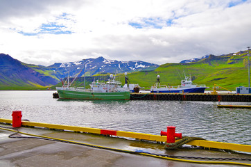 Fishing boats and cruise ship liner in port of Grundarfjordur on Iceland with beautiful landscape...