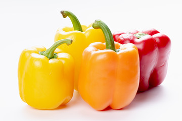 Four bell peppers that are different colors