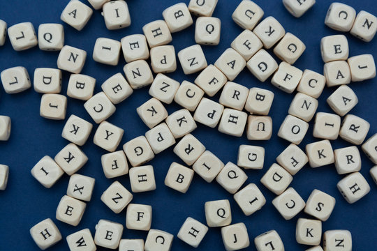 Wooden letter blocks over blue background, top view.