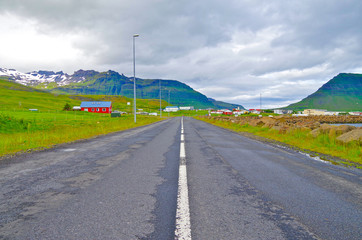 Empty road or street in Icelandic nature with green mountains