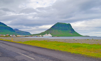 Kirkjufell Mountain with classic expedition cruiseship cruise ship liner Delphin docked at pier in...