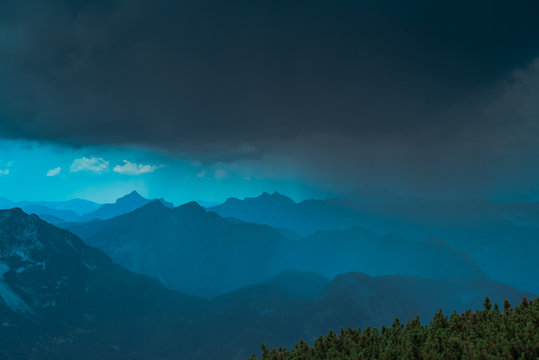 Dark storm clouds and rain come often unexpectedly out of the blue sky weather in high mountains, that is dangerous for unprepared hiking tourists. Austrian Dachstein Alps, UNESCO Salzkammergut Region