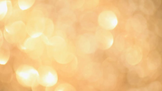 Shiny abstract textured background with golden lights, bokeh. Christmas, new year concept. Festive gold backdrop