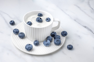 Blueberries in sour cream on marble surface