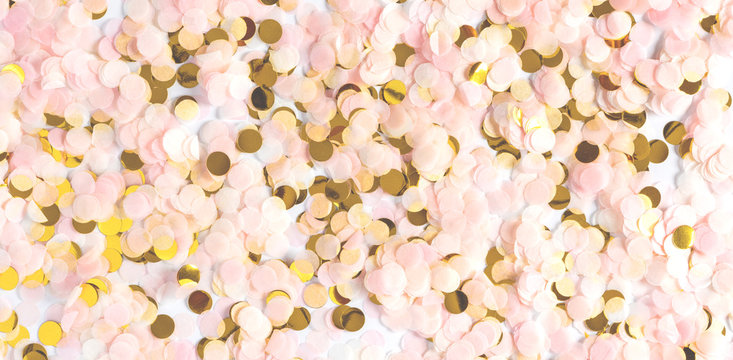 Gold and pink confetti on a white background. Soft festive background with confetti. Valentine's day, birthday or wedding background. Celebration or party backgrounds concepts ideas with confetti